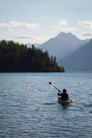Woman kayaker on St. Mary Lake, Glacier National Park, Montana, USA