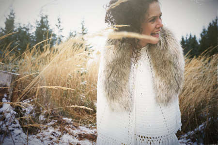 Mid adult woman wearing fur collar in forestの写真素材