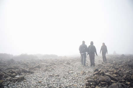 Three people walking through fog, Ben Nevis, Scotland