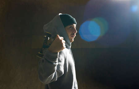 Portrait of young man holding skateboardの写真素材