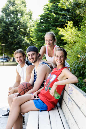 Portrait of four basketball players taking a break in parkの写真素材