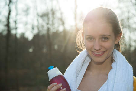 Portrait of young female runner taking a break for refreshment