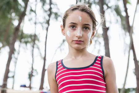 Portrait of young girl with suncream on her face, Krabi, Thailand, Southeast Asiaの写真素材