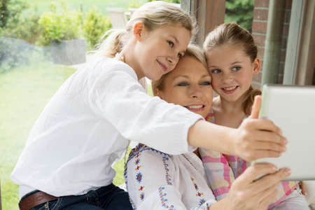 Mother and daughters using digital tablet