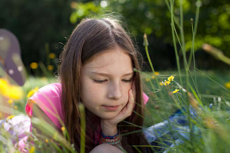 Girl lying in grass daydreaming