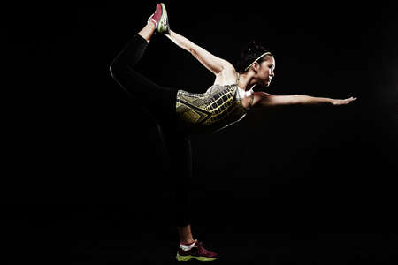 Young woman standing on one legの写真素材