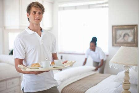 Waiter and chambermaid in holiday apartment bedroomの写真素材