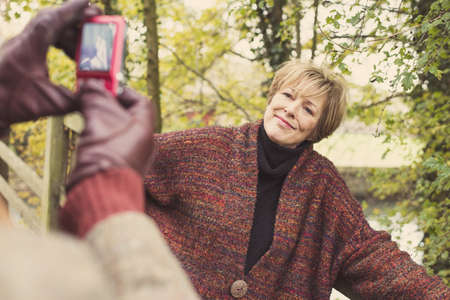 Man taking photo of woman on camera phone