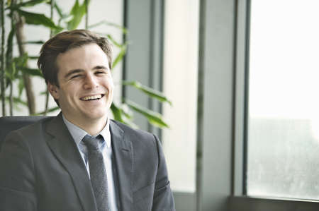 Portrait of young businessman at office deskの写真素材