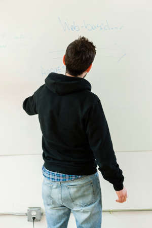 Male designer drawing on whiteboard in studio