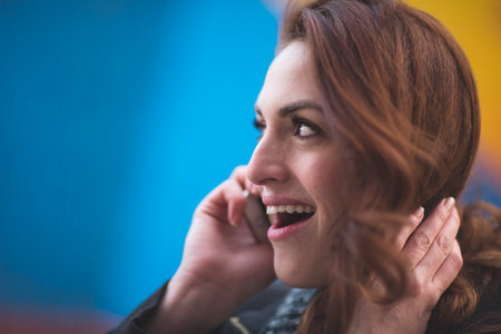 Young businesswoman talking on cellphone on city streetの写真素材