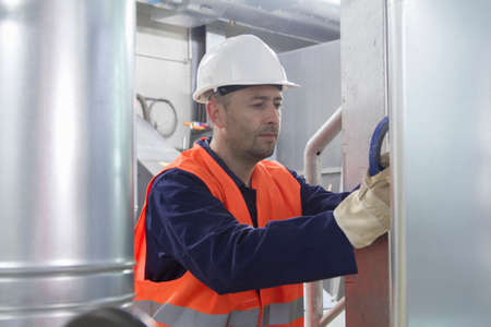 Technician making a check to pipes in power station