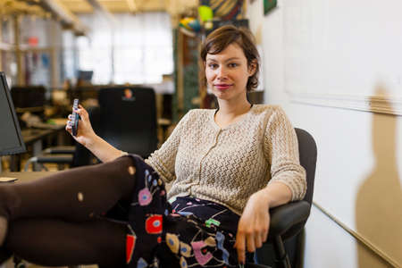 Young female designer with feet up in design studio