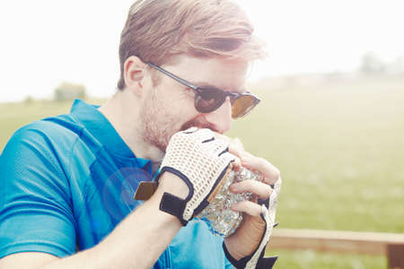 Cyclist eating sandwich with gloved hands