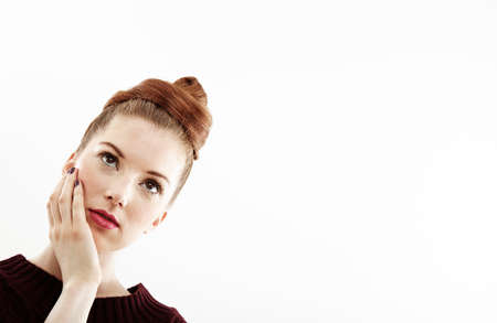 Studio portrait of beautiful young woman with hand on face