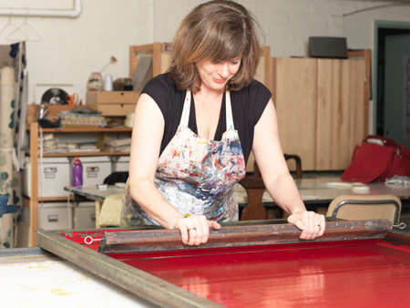 Woman hand-printing textile in workshop