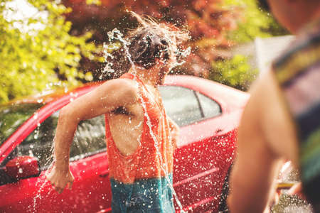Young man being sprayed with waterの写真素材