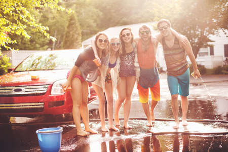 Five friends with arms around each other, portraitの写真素材