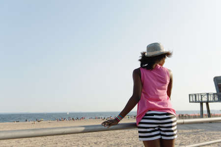 Rear view of young woman at beach, Coney Island, Brooklyn, New York, USAの写真素材