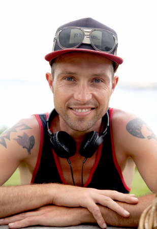 Portrait of smiling mid adult man wearing baseball cap at coast
