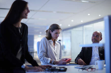 Business colleagues chatting over desk in office
