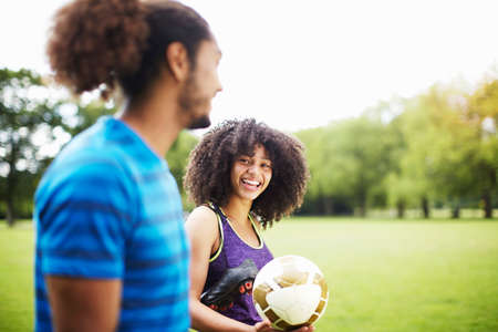 Young soccer couple chatting in parkの写真素材