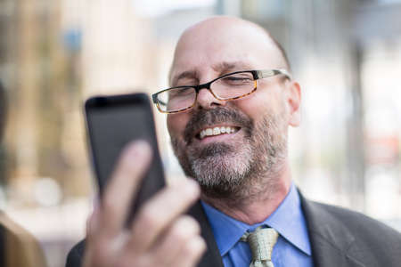 Mature man using smartphone, close up