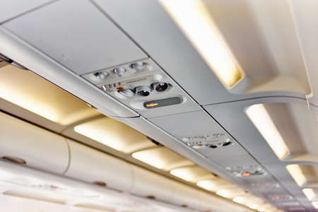 Ceiling of airplane above passenger seatの写真素材