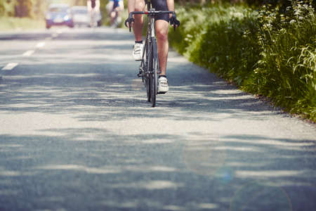 Cyclists riding on single carriageway, Cotswolds, UK
