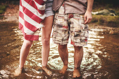 Young couple standing in shallow waterの写真素材