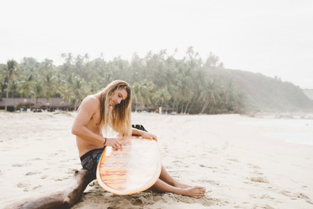 Australian surfer preparing surfboard, Bacocho, Puerto Escondido, Mexicoの写真素材