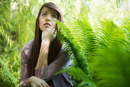 Woman kneeling by fernの写真素材