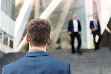 Rear view of young businessman outside office building, London, UKの写真素材