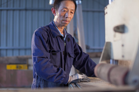 Carpenter working on wood flooring in factory, Jiangsu, Chinaの写真素材