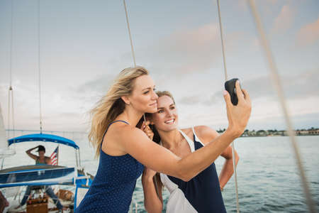 Friends photographing themselves on sailing boat