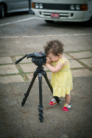 Cute baby girl playing with a tripodの写真素材