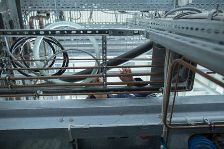 Low angle view of female engineer examining industrial pipework in factory