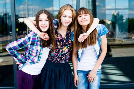 Portrait of three smiling young women in cityの写真素材