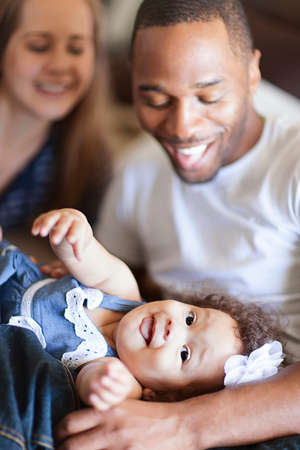 Mother and father playing with baby daughterの写真素材