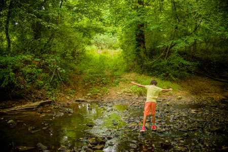 Boy at edge of streamの写真素材