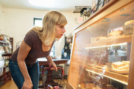 Female customer looking at display cabinet in country storeの写真素材