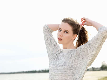 Young woman adjusting ponytail
