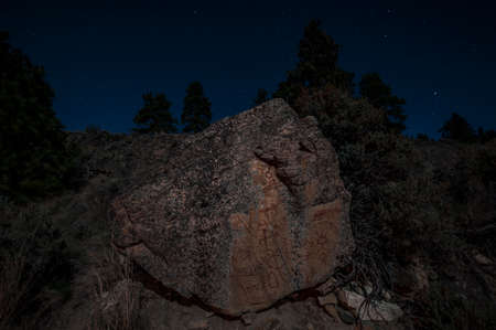 Pictographs on granite boulder at night, Naramata, British Columbia, Canada