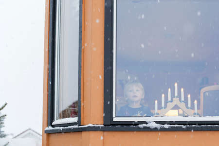 Boy waiting behind window