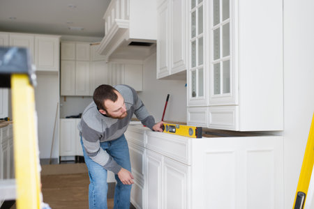 Carpenter installing kitchen cabinetの写真素材