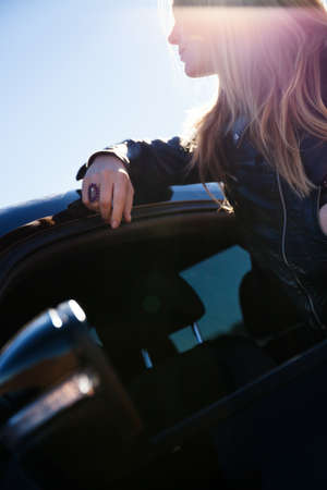 Woman leaning on car