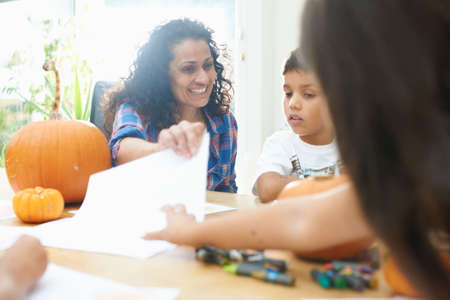 Mother and children drawing at dining table