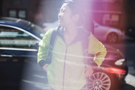 Young woman standing near road, cars behindの写真素材