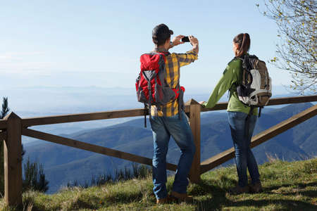 Hikers taking photograph of mountains, Montseny, Barcelona, Catalonia, Spain
