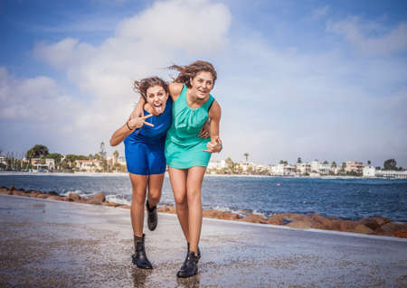 Portrait of two young women friends fooling around on promenadeの写真素材